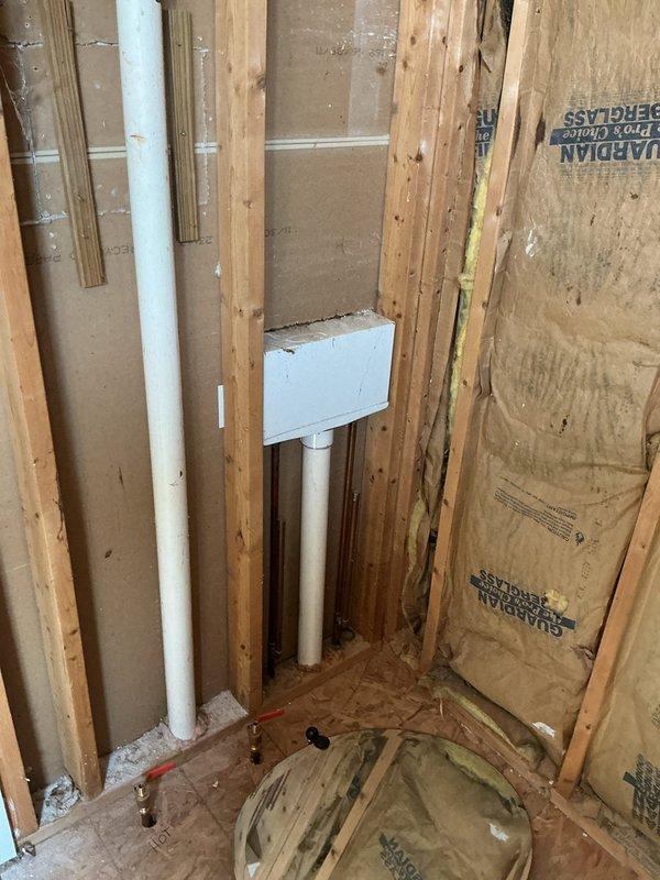 Conducted on-site assessment for rough plumbing installation of new shower in a 20-year-old single-family residence. Evaluated existing framing, insulation, and subfloor conditions in the designated bathroom area where white PVC supply lines and drainage connections are being roughed in through wall studs and floor penetrations. Documented the installation progress with photos showing proper pipe placement, mounting brackets, and preparation for future fixture connections, with all rough plumbing work positioned for code-compliant shower installation once framing inspection is complete.