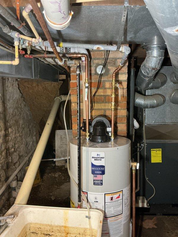 Successfully completed installation of a 40-gallon Bradford White natural gas water heater in basement utility area. Removed existing unit and installed new water heater with proper copper pipe connections, gas line hookup, and venting system. All plumbing connections were secured with brass fittings, ensuring code-compliant installation alongside existing HVAC system. Unit was tested for proper operation, verified all safety features, and confirmed no leaks in water or gas lines. Installation time totaled approximately 6 hours and included complete system commissioning.