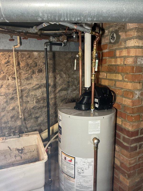 Successfully completed installation of a 40-gallon Bradford White natural gas water heater in basement utility area. Removed existing unit and installed new water heater with proper copper pipe connections, gas line hookup, and venting system. All plumbing connections were secured with brass fittings, ensuring code-compliant installation alongside existing HVAC system. Unit was tested for proper operation, verified all safety features, and confirmed no leaks in water or gas lines. Installation time totaled approximately 6 hours and included complete system commissioning.