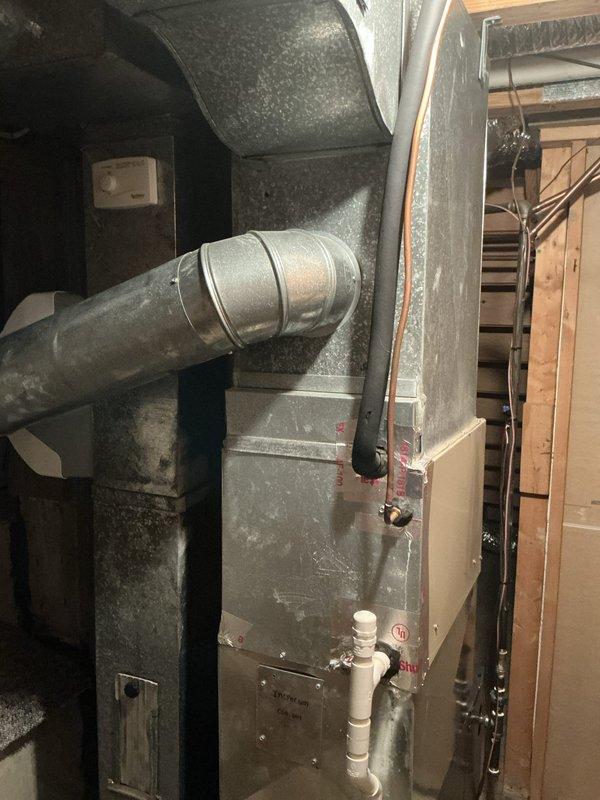 Performed air conditioning estimate on non-operational system in residential property with 18-year-old equipment. Documented existing HVAC installation including furnace unit with significant dust accumulation, ductwork configuration, and air handler components in basement utility area. System assessment completed to determine repair or replacement recommendations for customer consideration.