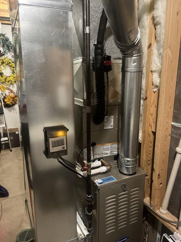 Completed full residential HVAC system installation in basement utility area, including new Carrier furnace unit and air conditioning system. Installed furnace with proper venting using white PVC piping, connected metallic ductwork and plenum assembly, and secured all connections with appropriate banding and clamps. Positioned equipment adjacent to existing water heater, ensuring proper clearances and access for future maintenance. Integrated electrical connections, mounted necessary controls, and verified all components were properly secured to wooden framing. Installation completed as same-day booking with all ductwork, refrigerant lines, and exhaust venting installed to manufacturer specifications.