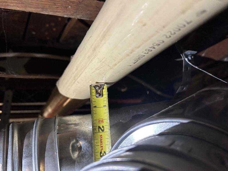 Corrected B-vent clearance violation by repositioning metallic vent pipe to achieve manufacturer-required minimum 1-inch clearance from combustible PVC pipe. Verified proper spacing with measurements and documented corrected installation to meet code compliance standards.