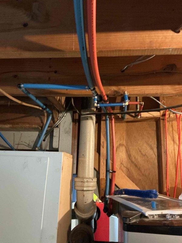 Completed comprehensive repiping of water distribution lines in basement utility area, replacing existing plumbing with new PEX and copper piping infrastructure. Installed customer-supplied three-stage water filtration system with blue cylindrical filter housings and KIND brand control panel, mounting unit securely to cinderblock wall. Configured manifold system with brass fittings and shut-off valves to integrate filtration system with existing water softener tank and main water distribution lines. All connections pressure-tested and verified for proper operation.