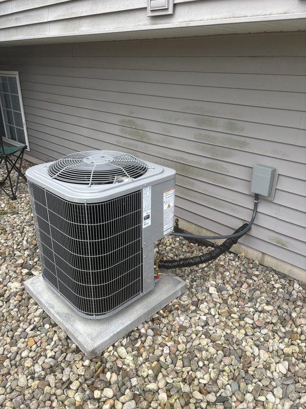 Completed full HVAC system installation including new furnace and air conditioning unit. Outdoor condensing unit installed on concrete pad with proper gravel base, refrigerant lines run and insulated along exterior wall, electrical disconnect mounted per code. Indoor furnace installed with all necessary ductwork connections, gas line hookup, and proper venting. All components tested and verified operational upon completion.