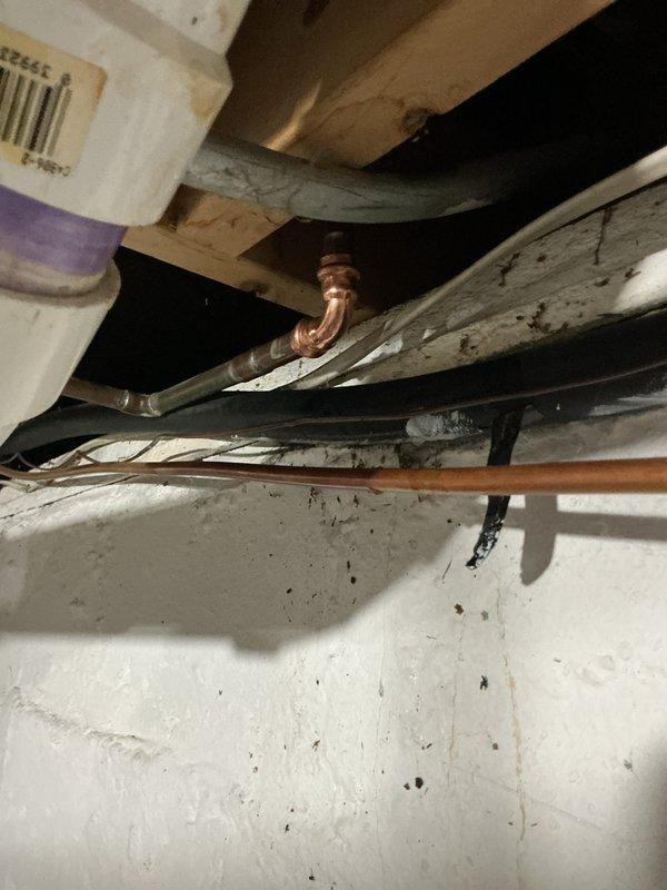 Responded to plumbing leak in basement of seventy-year-old residence. Upon inspection, identified leaking copper pipe joint in crawl space area that had been actively leaking for approximately one week. Assessed aged copper piping system showing oxidation and patina consistent with original home construction. Repaired defective pipe fitting, verified system integrity, and confirmed no additional leaks present in accessible plumbing. Documented conditions with photographs for customer records.