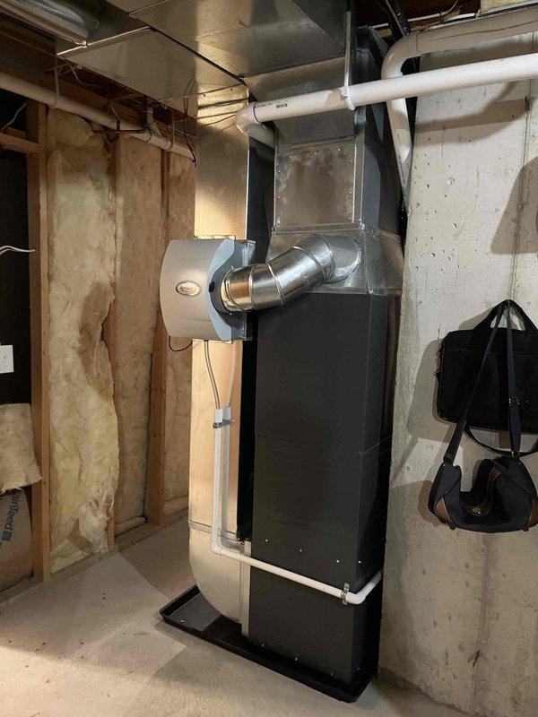 Completed full installation of Coleman furnace and air conditioning system in basement mechanical room. Installed new furnace unit on protective rubber mat with proper clearances, connected all necessary ductwork including vertical supply plenum and horizontal distribution system, and ran white PVC condensate drainage lines in U-trap configuration per code requirements. System tested and operational upon completion.