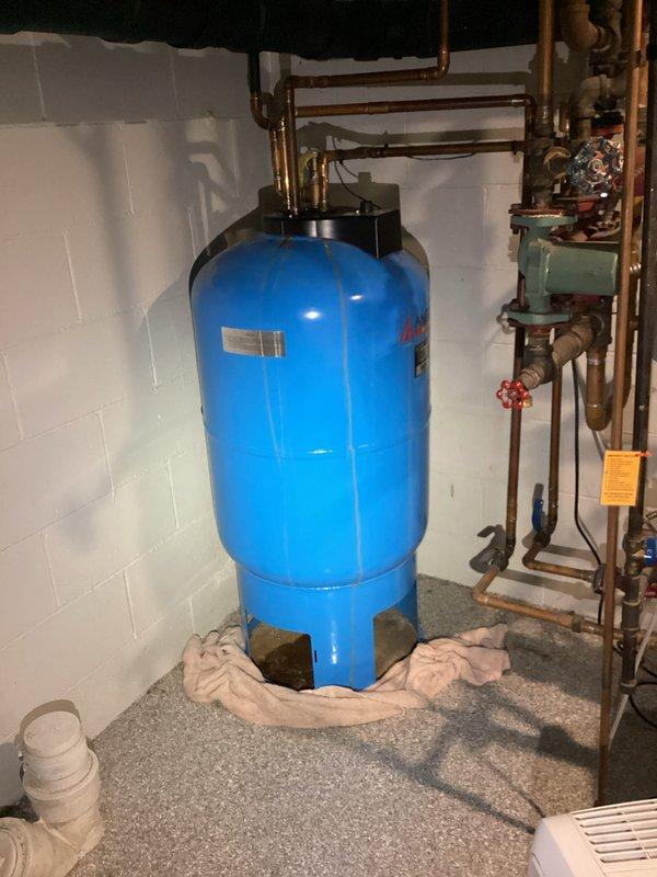 Responded to request for water heater replacement estimate at single family residence built in 1938. Upon arrival, assessed existing mechanical systems in basement utility area and documented current equipment configuration. Observed modern boiler system with Energy Star certification, extensive copper piping network with multiple valves and pressure gauge, expansion tank, and large blue pressure tank with associated plumbing connections. Photographed existing installation to provide comprehensive documentation for replacement estimate. Customer was not present during site visit as scheduled.