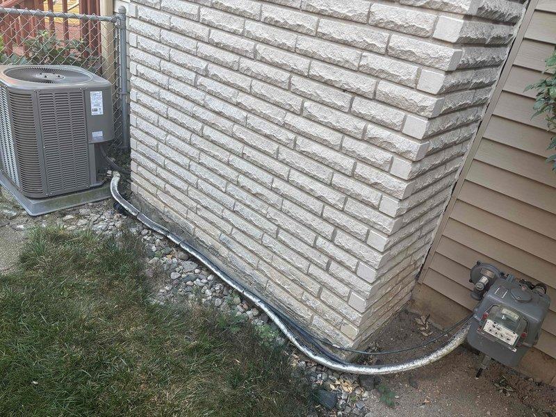 Completed annual cooling maintenance on 9-year-old Lennox system. Performed standard tune-up procedures including inspection of outdoor condenser unit, refrigerant lines, and electrical connections. Per client request, inspected insulation around penetration point where AC coils pass through interior wall—found insulation intact and properly sealed. Verified refrigerant line set routing along foundation, checked condenser operation, and confirmed all components functioning within normal parameters. System operating efficiently with no deficiencies noted.