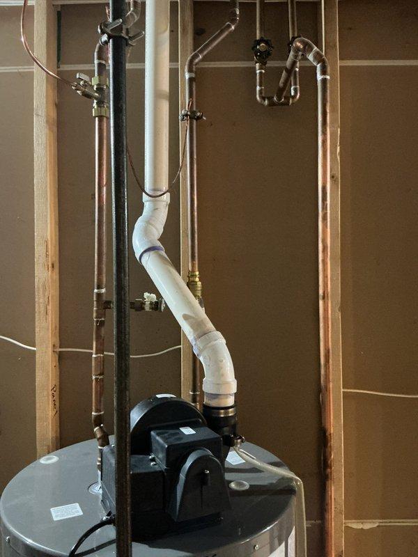 Responded to service call for noisy water heater still in operation. Inspected 7+ year old Rheem unit and identified noise consistent with sediment buildup in tank. Evaluated overall condition of water heater, plumbing connections, and associated components including recirculation pump mounted on top of unit. Documented existing installation with copper supply lines, PVC venting configuration, and shut-off valves. Advised customer that unit is approaching end of typical service life and noise indicates internal deterioration that will likely require replacement in near future, though system remains functional at present time.