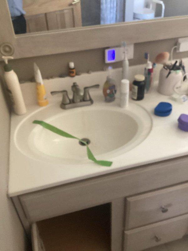 Responded to bathroom sink leak complaint and performed comprehensive plumbing inspection. Examined under-sink cabinet plumbing connections, including hot and cold water supply lines with shut-off valves and P-trap drain assembly. Inspected all visible plumbing components for signs of active leaks, loose connections, and proper installation. Tested water flow at bathroom vanity sink and monitored supply lines and drain connections during operation to identify source of reported leak. Checked all downstairs sinks for proper drainage function and flow rates. All plumbing connections found secure with no active leaks detected at time of inspection. Documented existing plumbing configuration with photos for service records.