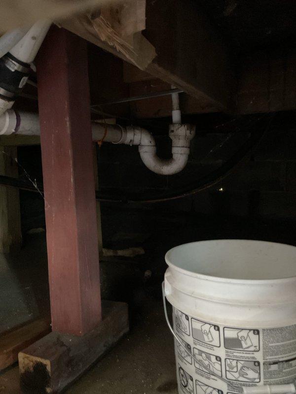 Responded to water leak reported underneath 21-year-old Comfortmaker furnace. Upon inspection, identified leak source in vicinity of heating system in basement area. Documented conditions with photographs showing plumbing infrastructure, support structures, and affected area beneath furnace location. System confirmed operational for both heating and cooling functions at time of visit. Placed containment materials including bucket and protective mat to manage water intrusion while assessment was conducted.