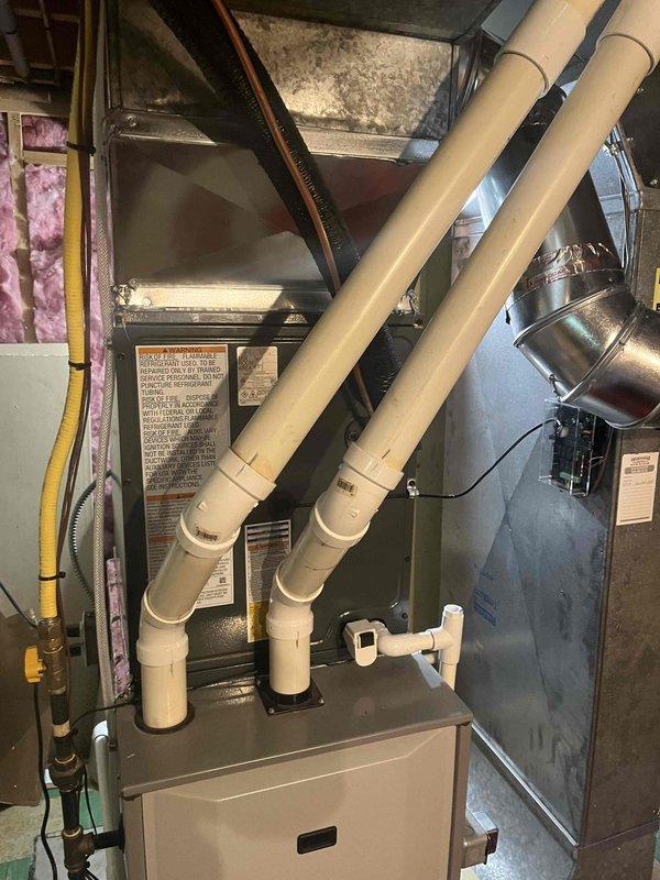 Completed full air conditioning system replacement at residential property. Installed new furnace unit in basement mechanical room with proper venting configuration utilizing dual PVC exhaust and intake pipes. Connected metallic ductwork to main unit and verified all connections secure. Installed outdoor condensing unit with A2L refrigerant safety classification. System charged with 54 ounces total refrigerant per manufacturer specifications. Verified all electrical connections, tested system operation, and confirmed proper airflow throughout. All equipment labeled appropriately with safety and technical information per code requirements.