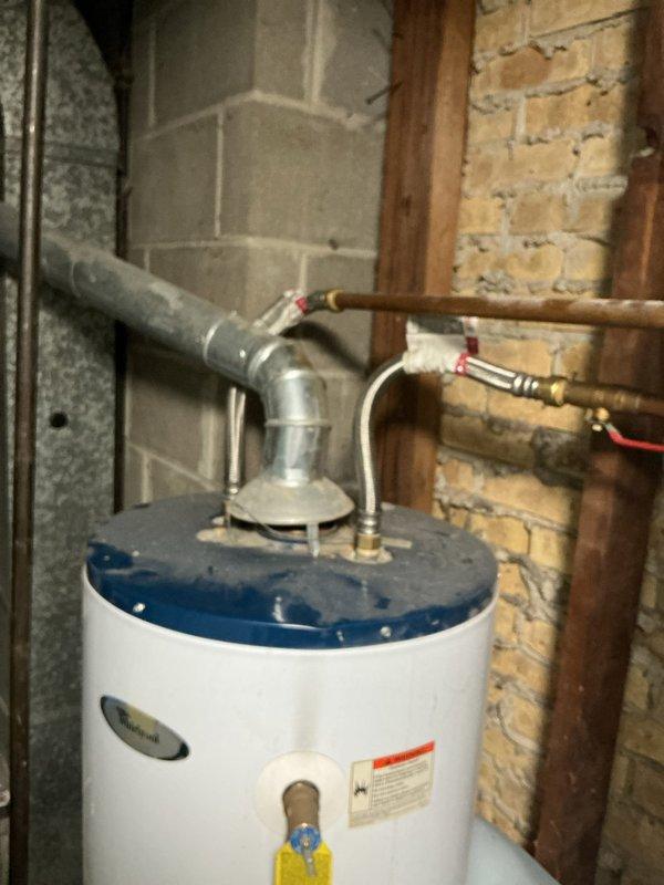 Responded to service call for 20-year-old Whirlpool natural gas water heater (model FG1F4040S3NOV) with pilot light failure. Diagnosed broken gasket in two pieces causing pilot to extinguish when reset button released. Provided estimate for complete replacement unit installation including proper permitting, removal and disposal of existing water heater, inspection and potential replacement of vent/flue system, brand and model recommendations with warranty details, and professional installation per code requirements for single-family residential application.