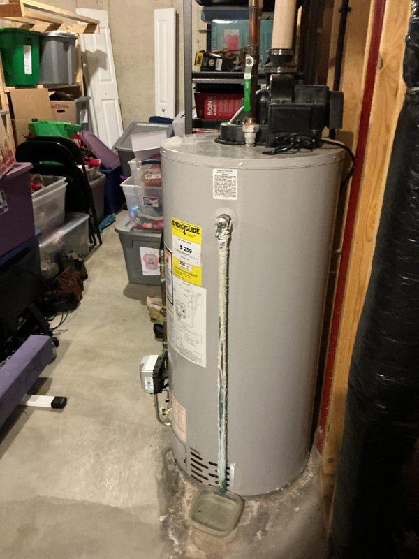 Responded to water heater efficiency complaint on 12-year-old Bradford White unit. Inspected unit and found significant calcium buildup on pipes and water heater connections, consistent with hard water mineral deposits. Customer reported decreased heating efficiency requiring thermostat adjustment to maximum setting. Documented existing conditions with photos showing mineral accumulation at pipe connections and overall unit condition. Advised customer that calcium buildup restricts water flow and reduces heat transfer efficiency, contributing to performance decline typical of units approaching end of service life without regular maintenance.