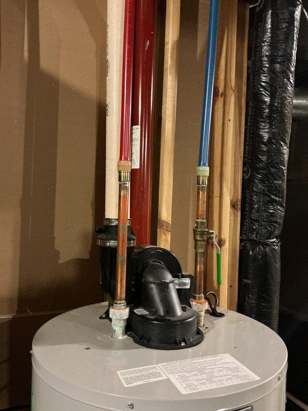 Responded to water heater efficiency complaint on 12-year-old Bradford White unit. Inspected unit and found significant calcium buildup on pipes and water heater connections, consistent with hard water mineral deposits. Customer reported decreased heating efficiency requiring thermostat adjustment to maximum setting. Documented existing conditions with photos showing mineral accumulation at pipe connections and overall unit condition. Advised customer that calcium buildup restricts water flow and reduces heat transfer efficiency, contributing to performance decline typical of units approaching end of service life without regular maintenance.