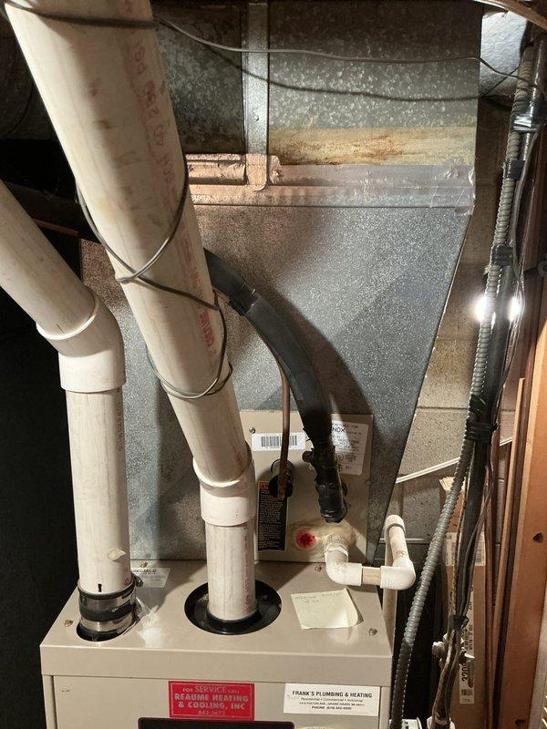 Conducted comprehensive assessment of existing furnace and air conditioning system for replacement estimate. Both units operational but showing age-related wear and reduced efficiency. Documented current installation including gas furnace with white PVC intake and exhaust venting, galvanized sheet metal supply plenum, and associated ductwork configuration in basement location. Photographed existing equipment layout, venting arrangement, electrical connections, and plumbing components to provide accurate proposal for new HVAC system installation.