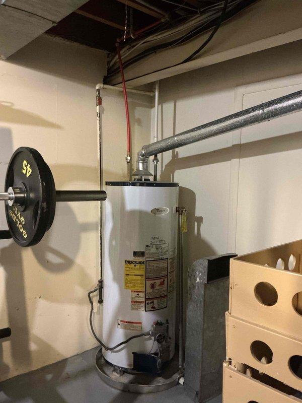 Provided estimate for replacement of existing conventional tank-type water heater with new tankless water heater system in approximately seventy-year-old residential property. Assessed current installation configuration, existing plumbing connections, venting requirements, electrical service capacity, and gas line specifications necessary for tankless conversion. Documented existing equipment condition and utility room layout with photographic records to support proposal development for complete system upgrade.