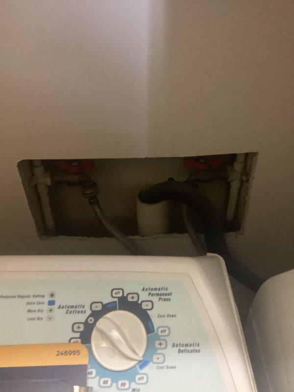 Responded to complaint of toilet water being siphoned during washing machine final rinse cycle. Investigated drainage system and identified improper venting causing negative pressure in the drain line. Accessed plumbing behind washing machine through wall opening to diagnose the issue. Determined that the washing machine drain was creating a siphon effect on the toilet trap due to inadequate air admittance. Corrected the venting deficiency to eliminate the cross-fixture siphoning problem and restore proper drainage function to both fixtures.