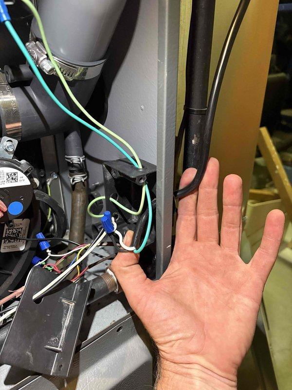 Responded to complaint of WD-40 like odor emanating from cold air return in living room area. Upon arrival, inspected 11-year-old furnace system and investigated odor source at multiple cold air return locations. Examined air filter for contamination and verified elevated odor concentration at upper living room return grille. Accessed furnace cabinet and inspected internal components including blower assembly, wiring connections, and condensate system for potential chemical odors or unusual substances. Photographed thermostat settings showing system operating in cooling mode and documented internal furnace components during inspection. No immediate mechanical failures or safety hazards identified during visual inspection of motor assembly, electrical connections, and piping systems.