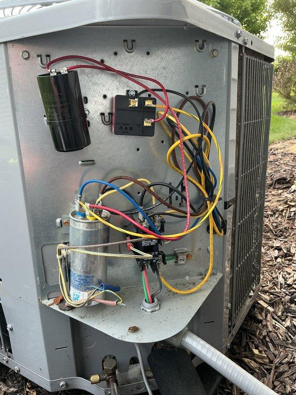 Completed annual cooling maintenance on 4-year-old Carrier condensing unit. Performed comprehensive system inspection including electrical component evaluation, capacitor testing, and contactor operation verification. Removed access panel to access electrical compartment and documented dual-run capacitor and relay connections. Inspected all electrical wiring connections and terminal blocks for proper torque and signs of overheating. Evaluated condenser coil condition and verified adequate clearance around unit. Organized loose wiring within electrical compartment for improved serviceability. Captured detailed photos of electrical components and interior configuration for maintenance records. System operating within normal parameters upon completion of tune-up service.
