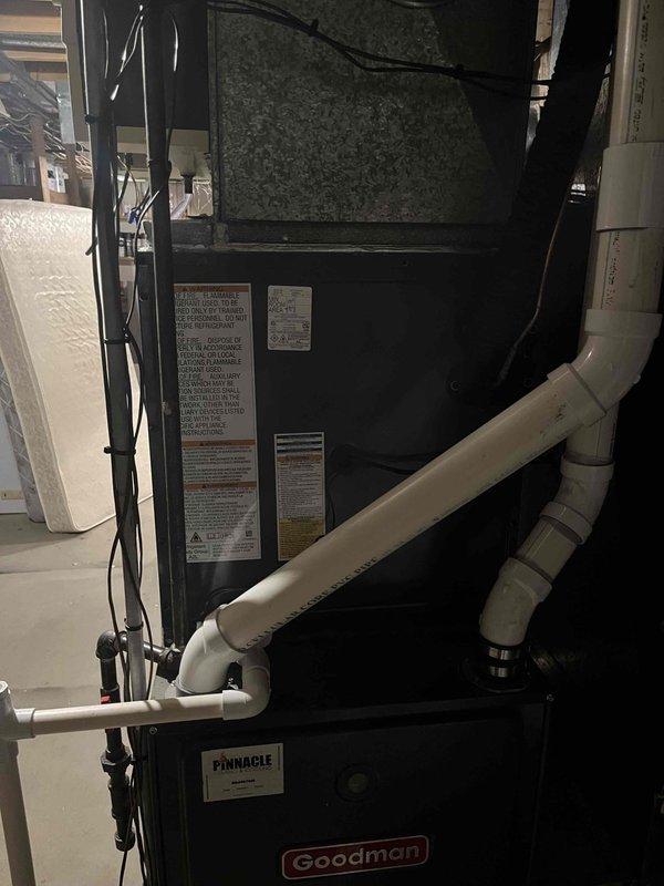 Completed full HVAC system replacement in residential basement mechanical room. Removed existing equipment and installed new Goodman Pinnacle furnace and air conditioning system with associated refrigerant lines, condensate drainage, and electrical connections. Configured PVC venting system with proper pitch and termination, routed copper refrigerant linesets, and established all necessary utility connections. System tested and verified operational upon completion.