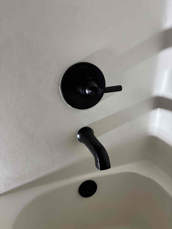 Completed installation of customer-supplied shower valve system featuring matte black tub and shower faucet set with single-handle control valve, wall-mounted spout, and coordinating drain cover. Accessed plumbing chase through wall cavity to connect PEX supply lines to new valve assembly using appropriate copper fittings and shut-off valves. Installed customer-supplied Toto toilet fixture to complete the bathroom upgrade. All installations tested for proper operation and leak-free connections.