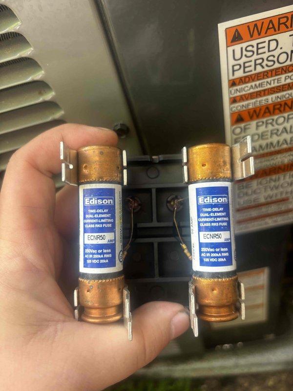 Completed annual cooling maintenance inspection on air conditioning system under warranty coverage expiring in 2036. During the tune-up, inspected and photographed the electrical disconnect fuse assembly, which contained two Edison brand time-delay dual-element current-limiting class RK5 fuses (ECNR50 and ECNR45 ratings) mounted in the fuse block, rated for 250VAC or less with 50kA interrupting capacity. All electrical components were found to be in proper working condition with no issues identified during the preventive maintenance visit.
