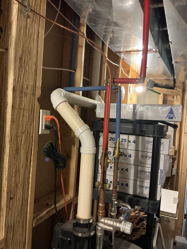 Conducted on-site evaluation for furnace and water heater replacement in a 2013-built residential property with original equipment. Assessed existing HVAC system including air handler with foil-wrapped ductwork, water filtration system with multiple cylindrical filter cartridges, and associated refrigerant lines. Evaluated white cylindrical water heater with PVC venting, copper supply connections, and pressure relief valve assembly. Documented mechanical room configuration including exposed framing, drainage systems, and utility connections. Photographed all equipment specifications, manufacturer labels, and installation components to provide accurate replacement recommendations for both units reaching end of serviceable life.