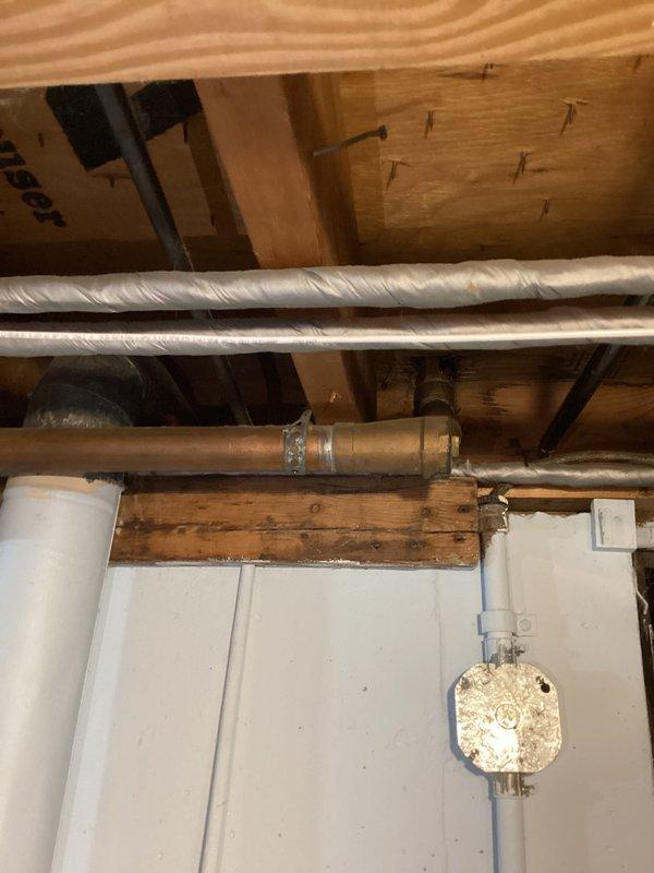 Performed comprehensive inspection of main sewer drain line in mid-1950s home previously converted from septic to city sewer system. Assessed visible rust and deterioration on vertical cast iron stack and associated drainage piping running from upper level fixtures down through basement to street connection. Documented condition of exposed plumbing infrastructure including corroded sections of main drain line, copper supply lines, and junction points. Photographed affected areas showing rust damage on black iron stack and surrounding pipe connections in basement utility area. Provided professional assessment and repair recommendations to address deterioration issues before potential failure occurs.