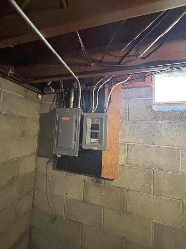 Conducted site assessment for relocating existing 35-year-old Bryant air conditioning unit from back porch to side of house, requiring approximately 30 feet of relocation distance. Documented current installation conditions including basement electrical infrastructure, circuit panel locations, and existing conduit routing to determine feasibility and scope of equipment relocation project.