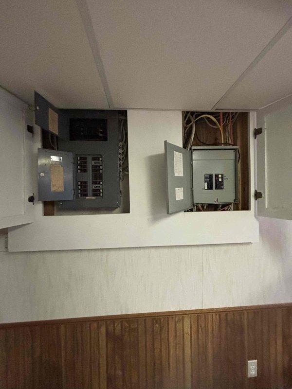Conducted comprehensive electrical assessment for main service panel upgrade with integrated whole-house surge protection and generator transfer switch installation. Evaluated existing electrical infrastructure including current panel configuration, circuit capacity, and available space for new equipment installation. Documented existing dual-panel setup with multiple circuit breakers and incoming service conductors to determine compatibility requirements for upgraded components. Provided detailed estimate for upgrading electrical service box to accommodate modern surge protection system and manual or automatic transfer switch to enable seamless generator backup power integration during utility outages.
