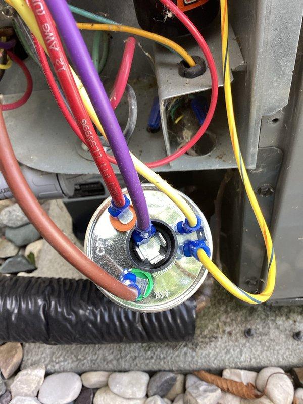 Completed annual cooling maintenance inspection on residential HVAC system. Performed comprehensive tune-up including visual inspection of outdoor condensing unit, electrical connections, and wiring terminations. Verified all wire connections at terminal block and capacitor are secure with proper color-coded terminations. Inspected unit mounting on concrete pad with decorative rock landscaping. All electrical components including capacitor, relay assembly, and control wiring found in good working condition. System operating within normal parameters. Unit ready for cooling season.