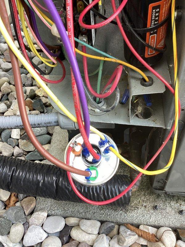Completed annual cooling maintenance inspection on residential HVAC system. Performed comprehensive tune-up including visual inspection of outdoor condensing unit, electrical connections, and wiring terminations. Verified all wire connections at terminal block and capacitor are secure with proper color-coded terminations. Inspected unit mounting on concrete pad with decorative rock landscaping. All electrical components including capacitor, relay assembly, and control wiring found in good working condition. System operating within normal parameters. Unit ready for cooling season.