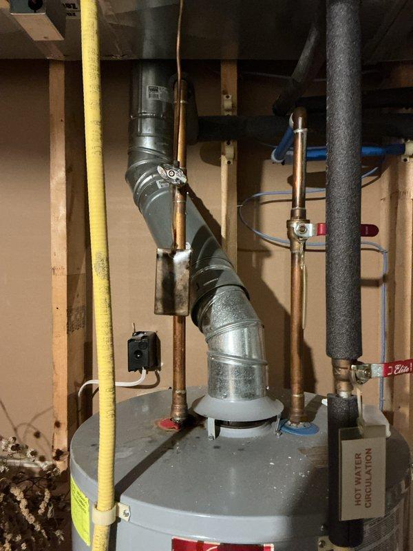 # Water Leak Service Completion

Responded to water leak service call at residential property. Upon inspection of basement utility area, identified active leak originating from water heater plumbing connections. Performed thorough examination of water heater installation, including copper piping, pressure relief valve connections, and inlet/outlet fittings. Tightened loose compression fittings at cold water inlet and inspected expansion tank connections for signs of moisture or corrosion. Verified proper operation of blue-handled shut-off valves and confirmed gas line connections were secure and properly sealed. Checked floor area around water heater base for water accumulation and assessed extent of moisture damage to concrete floor. Tested all plumbing connections under pressure to ensure leak was resolved. Verified proper venting through metallic exhaust ductwork and confirmed water heater was operating safely. Left work area clean and advised on monitoring for any recurring moistur
