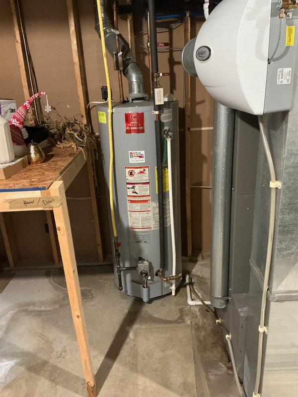 # Water Leak Service Completion

Responded to water leak service call at residential property. Upon inspection of basement utility area, identified active leak originating from water heater plumbing connections. Performed thorough examination of water heater installation, including copper piping, pressure relief valve connections, and inlet/outlet fittings. Tightened loose compression fittings at cold water inlet and inspected expansion tank connections for signs of moisture or corrosion. Verified proper operation of blue-handled shut-off valves and confirmed gas line connections were secure and properly sealed. Checked floor area around water heater base for water accumulation and assessed extent of moisture damage to concrete floor. Tested all plumbing connections under pressure to ensure leak was resolved. Verified proper venting through metallic exhaust ductwork and confirmed water heater was operating safely. Left work area clean and advised on monitoring for any recurring moistur