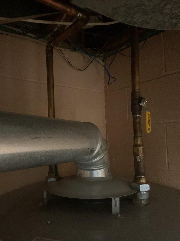 Responded to no cooling complaint at single family residence with 10-year-old air conditioning system experiencing reduced cooling capacity. Upon arrival, conducted visual inspection and documented equipment conditions including HVAC ductwork and associated mechanical systems in basement utility area. Photographed water heater data plate and ventilation components for service records. System assessment revealed unit still providing partial cooling function despite customer concerns.