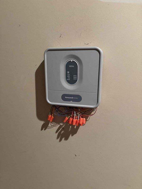 Responded to no cooling complaint for upstairs zone on 8-year-old Rheem system. Upon arrival, found thermostat and HZ311 zone control panel with exposed wiring requiring attention. Inspected multi-zone HVAC system, verified thermostat communication with zone controller, checked all wire terminations at control board terminals, and assessed system operation across all three zones. Addressed wiring concerns, secured connections, and restored proper cooling operation to affected upstairs zone.