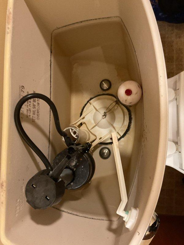 Responded to plumbing leak reported under bathroom sink in 50+ year-old home. Upon inspection, identified faulty toilet tank components as the source of the leak, including a deteriorating flapper valve and compromised fill valve assembly showing mineral deposits and discoloration. Replaced internal tank mechanisms, tested flush operation, and verified all connections were sealed properly to eliminate the ongoing leak that had persisted for approximately two weeks.