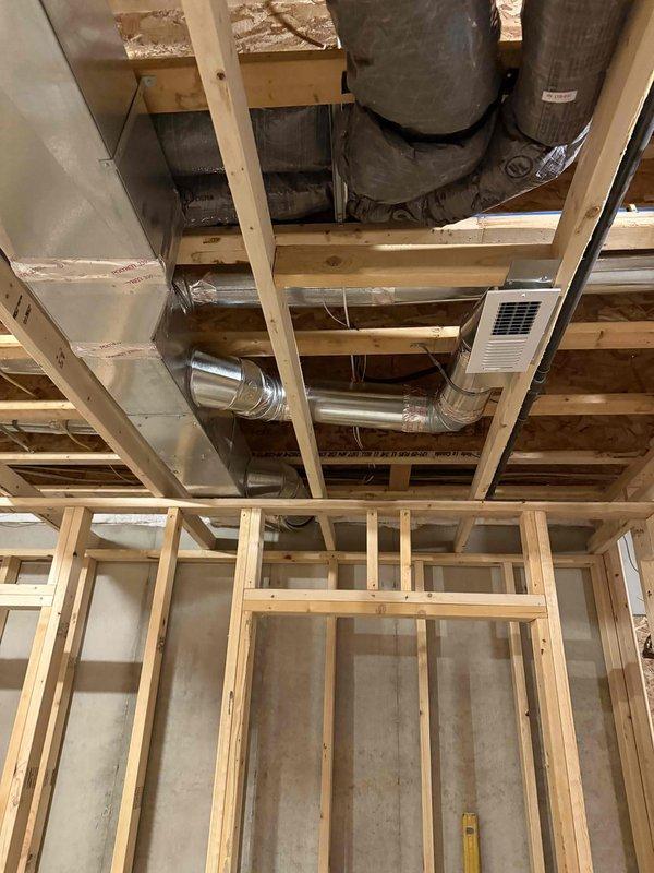 Installed new ceiling-mounted supply register and low wall return air grille in basement room undergoing finishing work. Extended flexible ductwork through exposed framing to accommodate new register locations, connecting to existing HVAC system. Permit obtained prior to installation per local building code requirements.