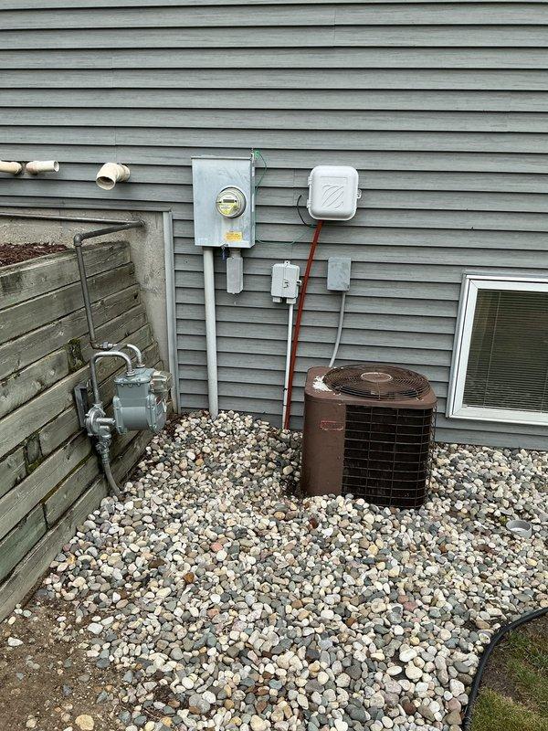 Completed comprehensive AC estimate for 16-year-old residential cooling system. Documented existing HVAC infrastructure including basement air handler, Bryant furnace with humidifier, water heater, and exterior condenser unit showing signs of age and weathering. Photographed complete system layout, ductwork connections, refrigerant line routing, electrical service components, and outdoor equipment placement for replacement proposal assessment.