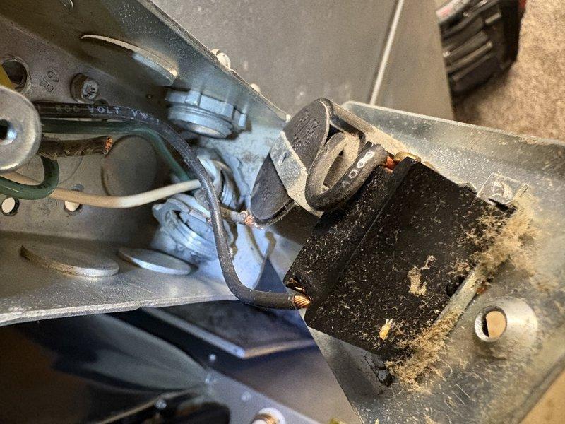 # NC-No Cool Service

Responded to service call for AC unit tripping breaker at furnace when turned on. Upon inspection, found heavily soiled blower assembly with significant dust and debris accumulation on blower motor and housing. Discovered compromised wiring with frayed and stripped conductors at terminal connections, creating potential short circuit condition. Identified exterior line set with corrugated conduit running through foundation area showing signs of environmental exposure. The breaker tripping was attributed to electrical fault caused by deteriorated wiring and excessive dirt buildup on motor components creating increased amp draw and potential ground fault.