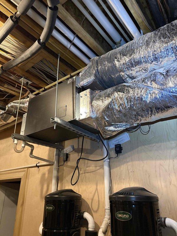Responded to service call for 7-year-old Fujitsu mini-split system not maintaining set temperature. Customer reported thermostat set to 74°F cooling mode but home temperature rising to 86°F instead of cooling properly. Inspected attic-mounted air handler unit and associated ductwork system. Evaluated system operation, thermostat communication, and temperature sensor functionality. Verified proper electrical connections, refrigerant lines, and duct insulation integrity. Documented equipment installation including air handler, insulated ductwork, and auxiliary HVAC components. Captured photos of mechanical space showing complete system layout for service records.