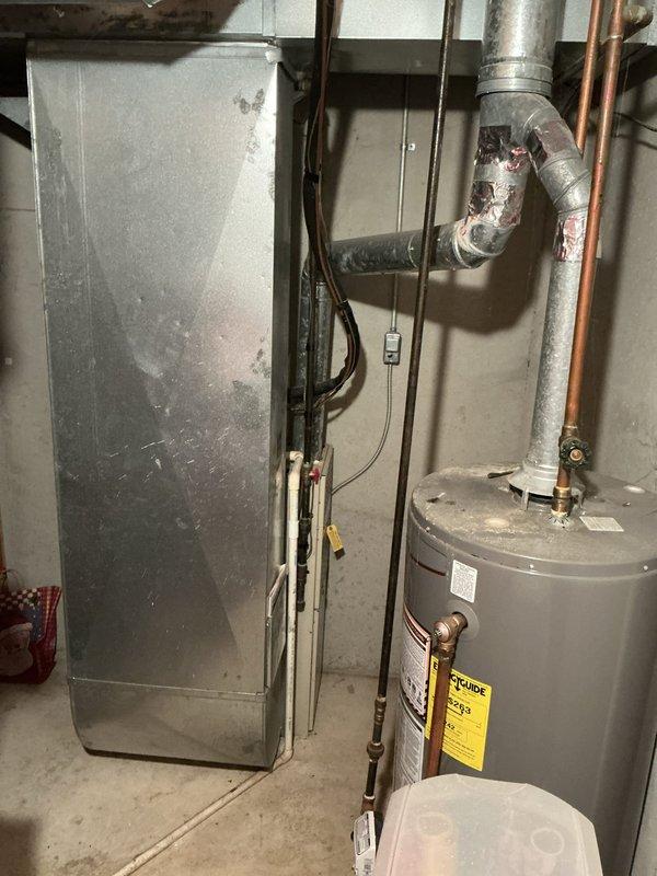 Conducted on-site evaluation of existing HVAC system in single-family residence to provide replacement estimate. Inspected 35-year-old furnace and air conditioning equipment located in basement, documenting current system configuration including ductwork, electrical connections, and venting arrangements. Assessed installation requirements and took detailed photographs of existing equipment layout to develop comprehensive replacement proposal for new heating and cooling system.