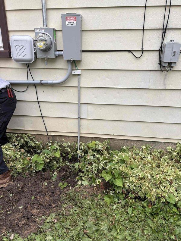Relocated grounding electrode conductor that was previously routed through a low-lying lawn area subject to flooding and interfering with mowing operations. Rerouted the ground wire along the foundation wall using appropriate conduit protection, securing it above grade level adjacent to existing electrical service equipment and meter base. The relocated grounding system now provides proper electrical safety while eliminating the landscape maintenance conflict and flood exposure risk.