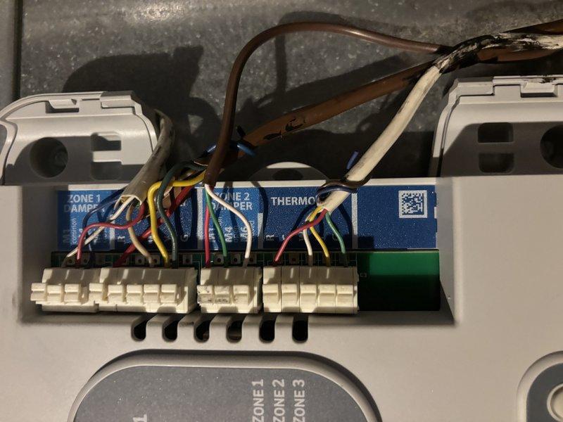 Completed zone motor repair on HVAC zoning system. Accessed zone control board, verified wiring connections to damper motor and thermostat terminals, and confirmed proper operation of Zone 1 damper control. Tested system functionality and secured all components within ductwork assembly.