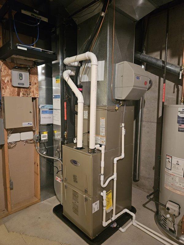 Completed full air conditioning system replacement at residential property. Removed existing HVAC equipment and installed new furnace unit in basement mechanical room with proper PVC intake and exhaust venting routed vertically. Installed new outdoor condenser unit on gravel pad adjacent to building exterior with proper refrigerant line connections secured to siding. Performed refrigerant recovery procedures using manifold gauges and recovery cylinder to properly evacuate and charge system to manufacturer specifications. Verified all electrical connections at panel box, tested system operation, and confirmed proper airflow through existing ductwork. All equipment installed per code requirements and manufacturer guidelines with system fully operational upon completion.