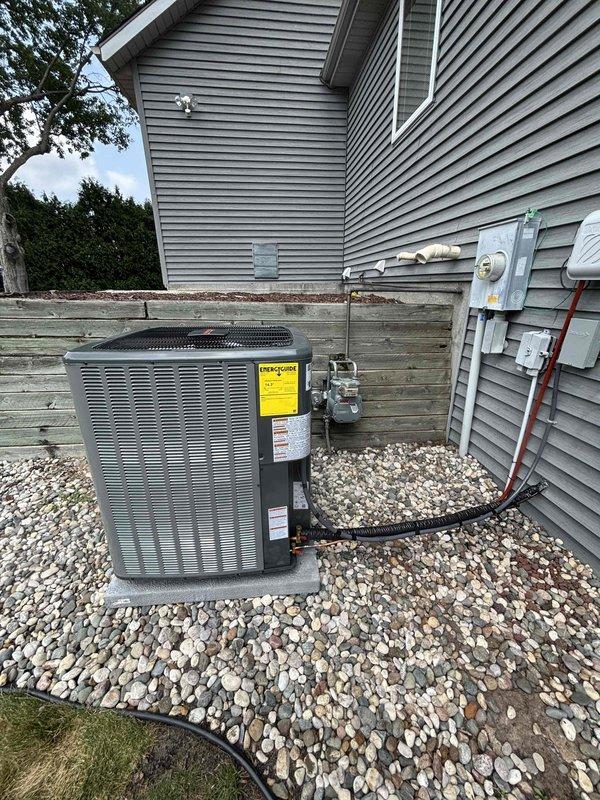 Completed full air conditioning system replacement at residential property. Removed existing HVAC unit and installed new Amana-branded condensing unit on existing concrete pad in side yard gravel bed. Ran new refrigerant lines with proper insulation from outdoor unit through exterior wall penetration to connect with indoor air handler. Verified all electrical connections at outdoor disconnect and metered service. Tested system operation, confirmed proper refrigerant charge, and validated all safety controls functioning correctly.