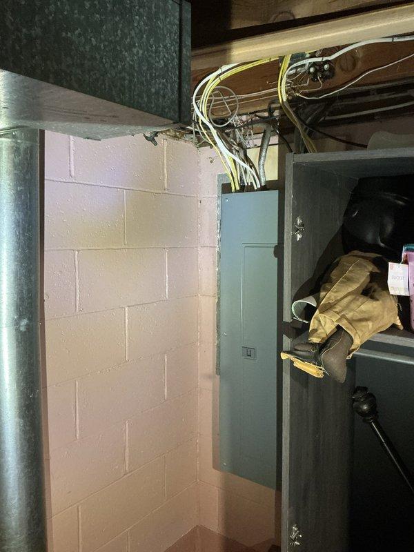 Responded to customer complaint of air conditioning unit running but not cooling to set temperature on a 10-year-old system. Performed diagnostic evaluation of HVAC equipment located in basement utility area. Inspected furnace unit, ductwork, electrical connections, and associated components including PVC condensate piping and air return plenum. Documented equipment condition and installation setup with photographic evidence showing gray metal furnace against cinder block wall, exposed electrical wiring, and overall system configuration. Provided estimate for necessary repairs to restore proper cooling functionality.