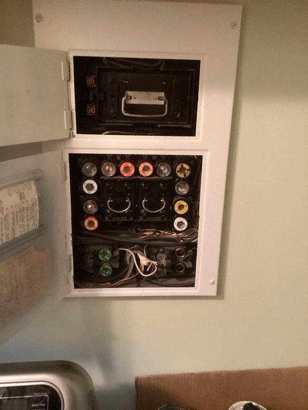 Conducted electrical assessment of existing breaker panel installation for potential replacement. Evaluated current two-section panel configuration with main disconnect switch and multiple circuit connections utilizing color-coded wire management grommets. Documented panel condition, wire routing, and overall electrical service setup in residential laundry area. Photographed existing installation to support estimate preparation for panel replacement project.