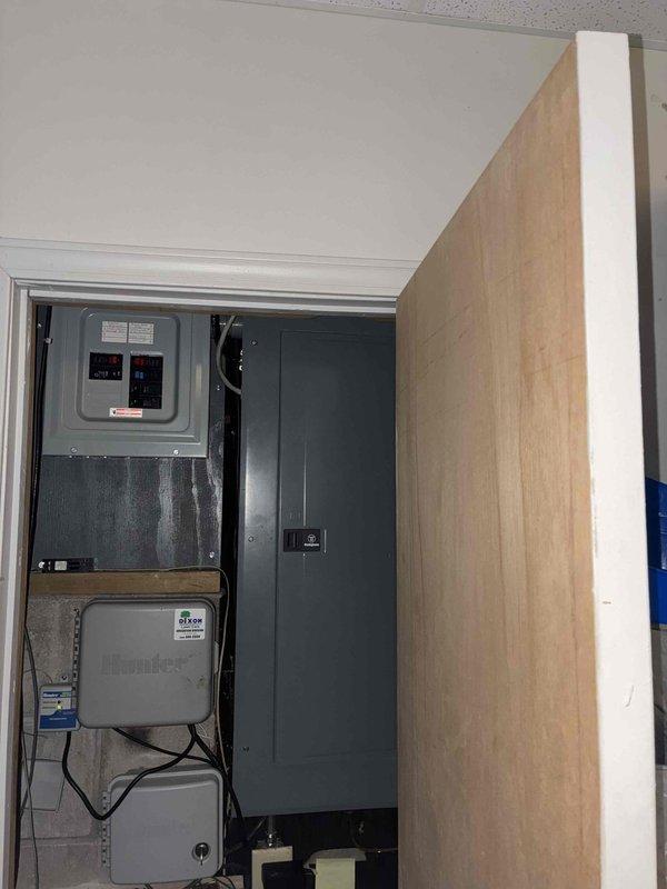 Conducted site evaluation for whole house generator installation at a single-family residence built in 1998 with no existing generator system. Assessed electrical service panel location in interior utility closet, documented existing electrical infrastructure including main breaker panel and service equipment, and evaluated available space for generator placement and necessary electrical connections. Photographed current electrical setup to determine proper sizing requirements and installation specifications for the proposed backup power system.